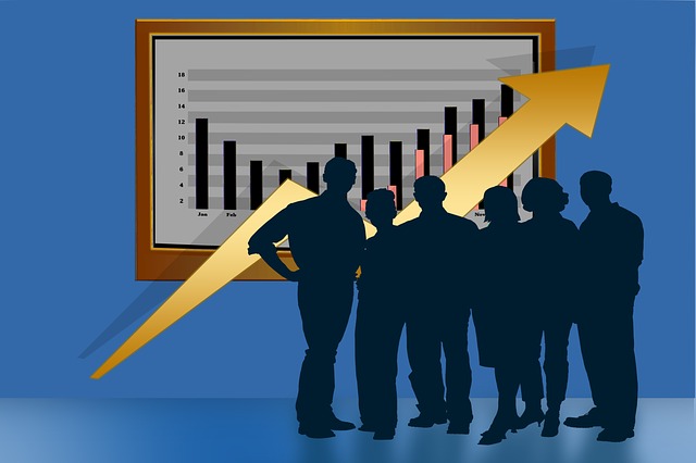Se muestra un grupo de personas ubicados delante de un tablón con estadísticas empresariales