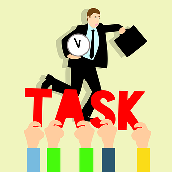 En la imagen se muestra un señor vestido de trabajo y unas manos que sujetan la palabra TASK que en español significa TAREA